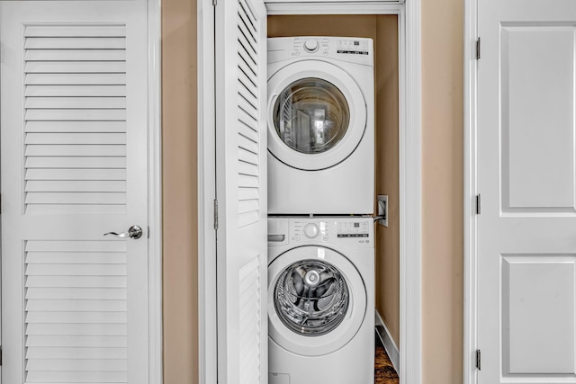 washroom with stacked washer and dryer and laundry area