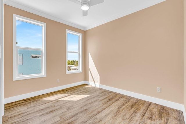 empty room with ceiling fan, baseboards, crown molding, and wood finished floors