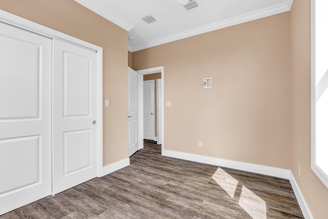 unfurnished bedroom featuring visible vents, wood finished floors, and ornamental molding