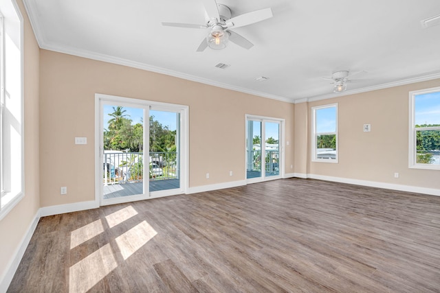 unfurnished room featuring visible vents, ornamental molding, and wood finished floors