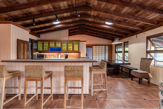 bar featuring vaulted ceiling with beams, wooden walls, track lighting, wooden ceiling, and tile patterned floors