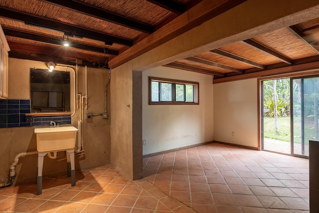 unfurnished room with light tile patterned flooring, beam ceiling, and wooden ceiling