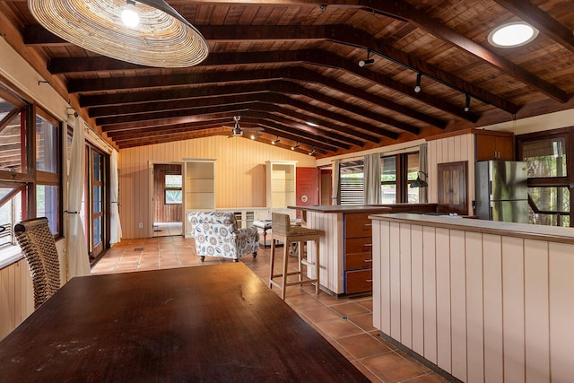 unfurnished dining area featuring lofted ceiling with beams, light tile patterned floors, and wooden ceiling