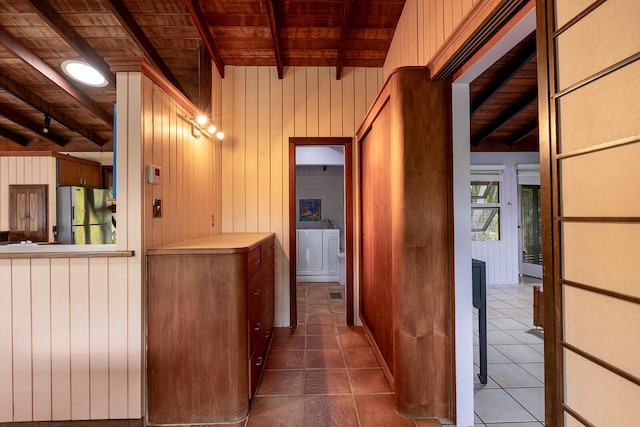 hall with washing machine and dryer, wooden walls, wooden ceiling, and beamed ceiling