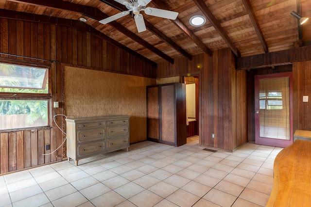 interior space with vaulted ceiling with beams, light tile patterned floors, wood ceiling, and wood walls