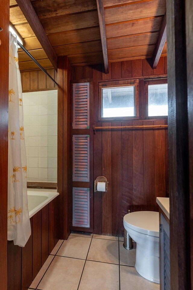 bathroom with a healthy amount of sunlight, wood ceiling, tile patterned floors, and beamed ceiling