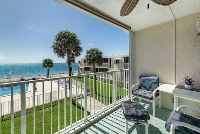 balcony featuring a water view and ceiling fan