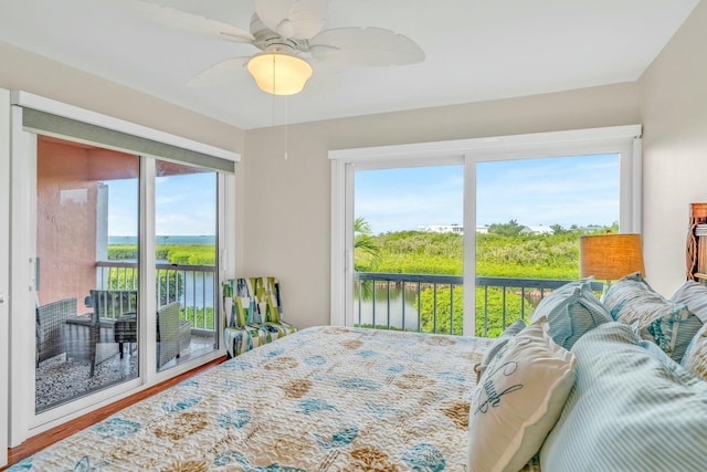 bedroom featuring multiple windows, access to outside, ceiling fan, and wood finished floors