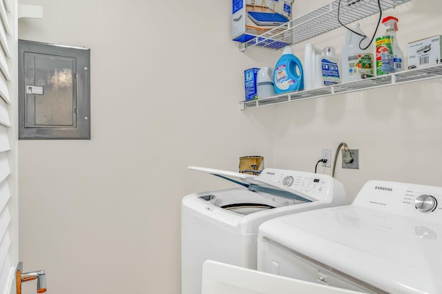 clothes washing area with electric panel, independent washer and dryer, and laundry area