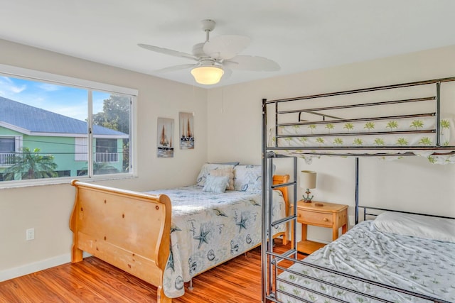 bedroom with baseboards, light wood-style floors, and a ceiling fan