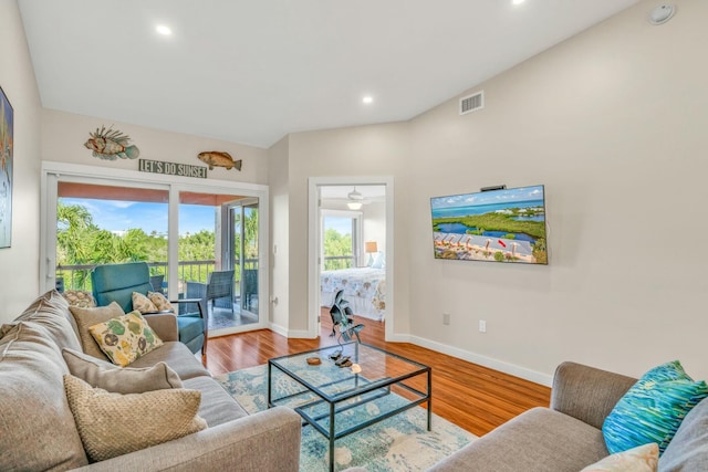 living room featuring baseboards, visible vents, wood finished floors, and recessed lighting