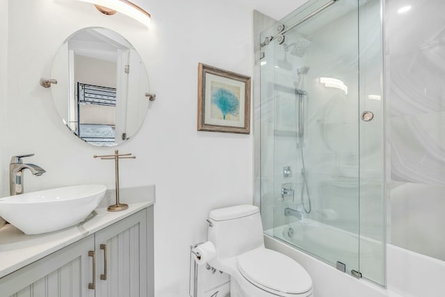 full bathroom with enclosed tub / shower combo, toilet, and vanity