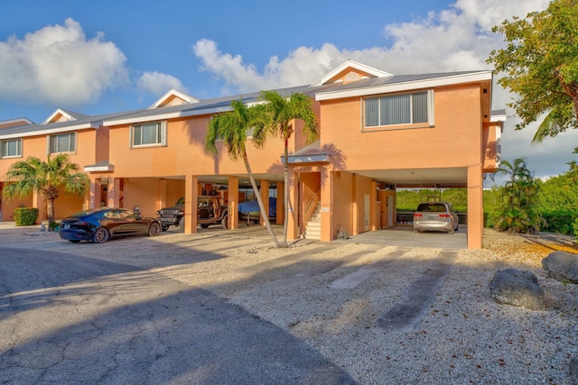 view of front of house featuring a carport and stucco siding
