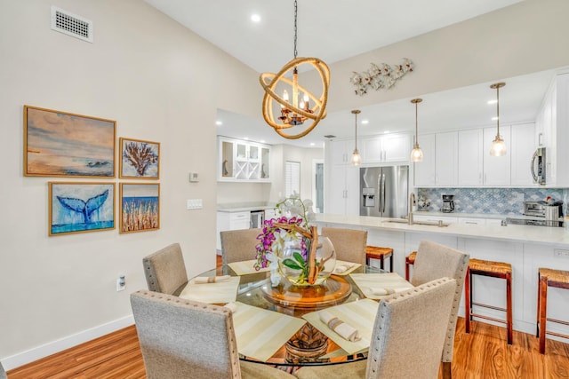 dining room featuring recessed lighting, an inviting chandelier, baseboards, visible vents, and light wood-style flooring