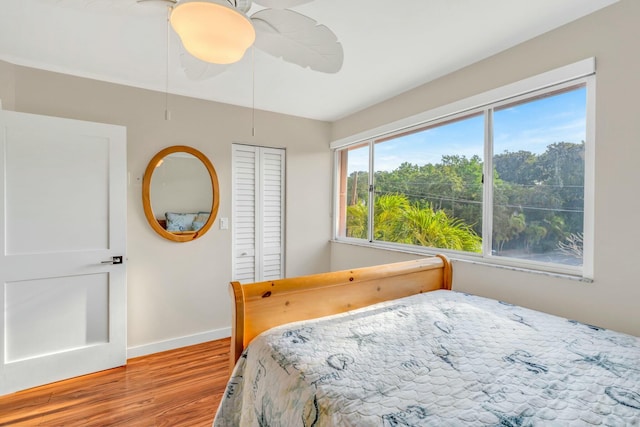 bedroom featuring light wood finished floors, baseboards, a closet, and a ceiling fan