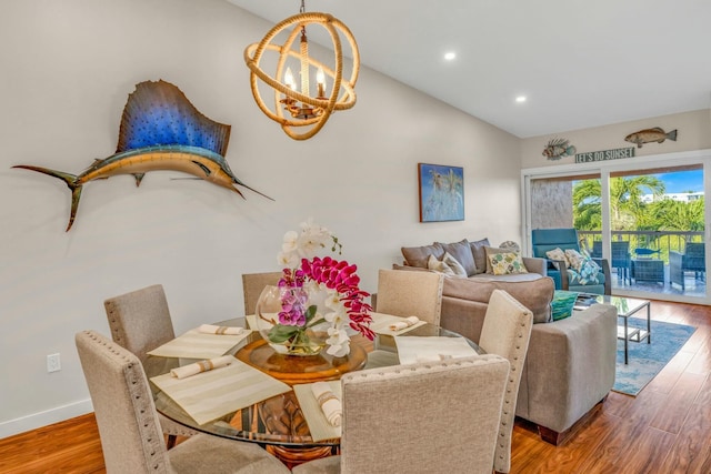 dining room featuring lofted ceiling, recessed lighting, an inviting chandelier, baseboards, and wood finished floors