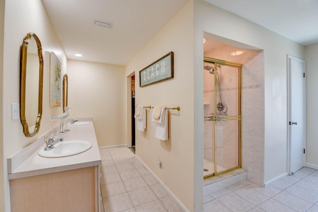 bathroom featuring vanity, a shower with shower door, and tile patterned floors