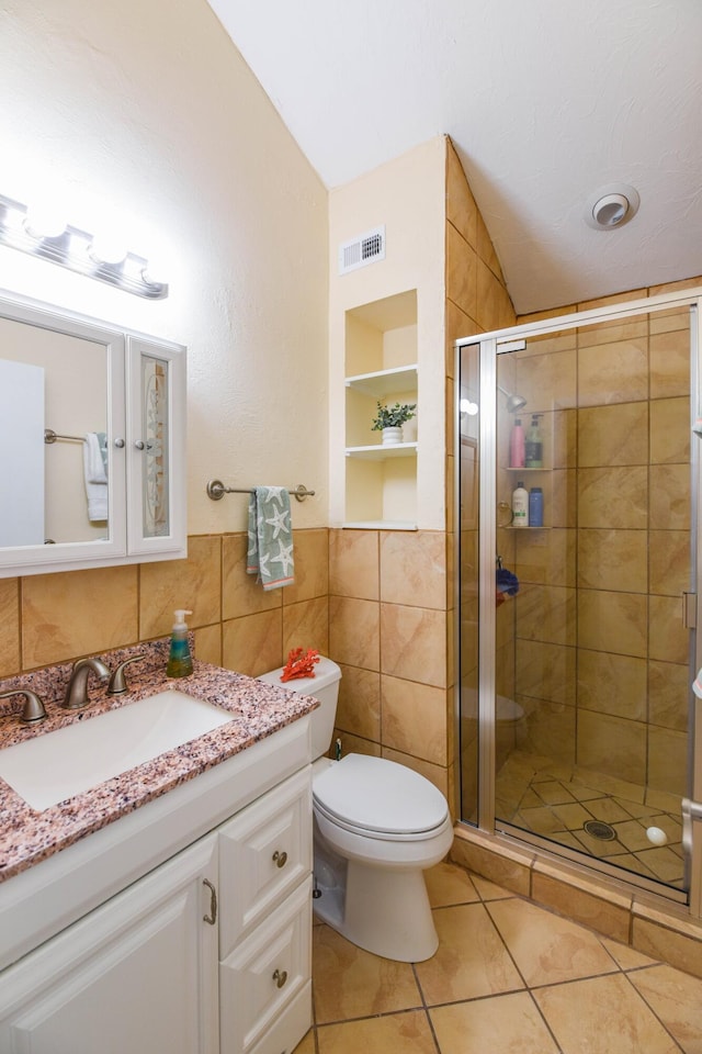 bathroom featuring tile walls, tile patterned flooring, vanity, walk in shower, and toilet