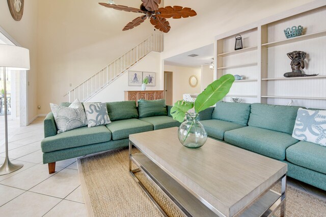 tiled living room featuring ceiling fan and a high ceiling