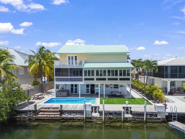 back of house with french doors, a patio, a water view, and a balcony