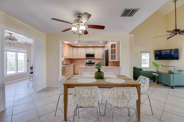 tiled dining area with sink and ceiling fan