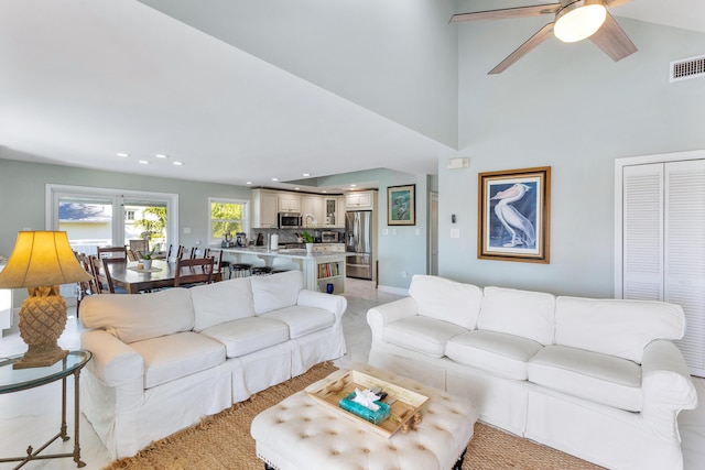 living room featuring a towering ceiling and ceiling fan