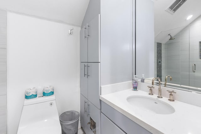 bathroom featuring a shower with door, vanity, lofted ceiling, and toilet