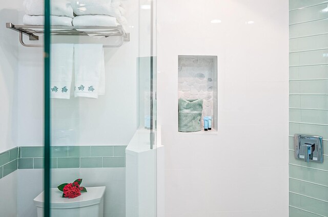 bathroom with tile walls and toilet