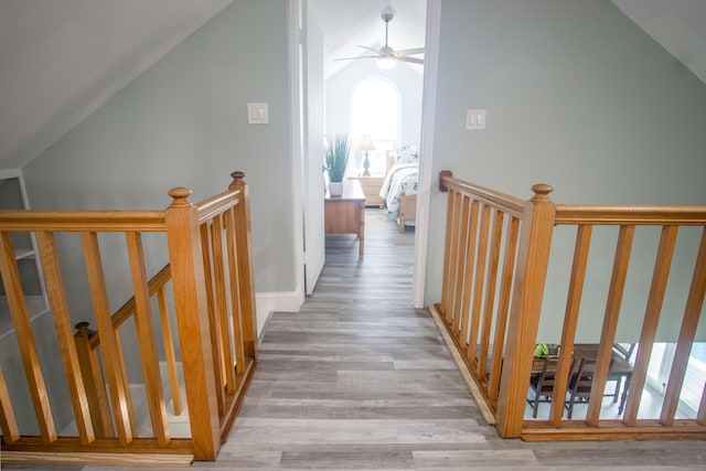 corridor featuring light hardwood / wood-style flooring and vaulted ceiling