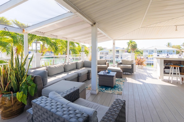 wooden terrace featuring a bar and an outdoor hangout area