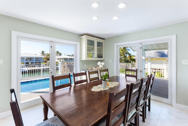 dining space featuring french doors and a water view