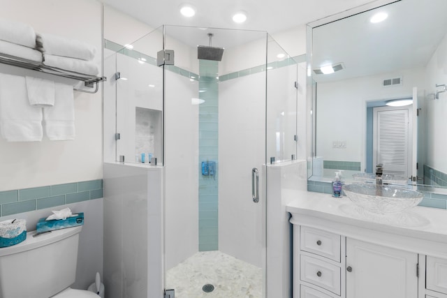 bathroom with vanity, toilet, and a shower with shower door