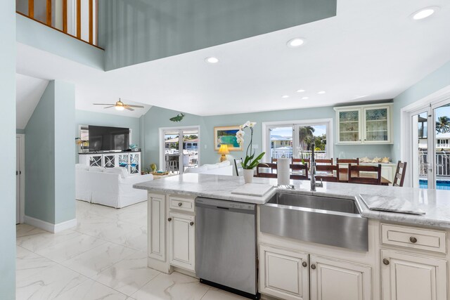 kitchen featuring lofted ceiling, sink, stainless steel dishwasher, ceiling fan, and light stone countertops