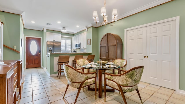 dining area featuring crown molding, a chandelier, and light tile patterned flooring