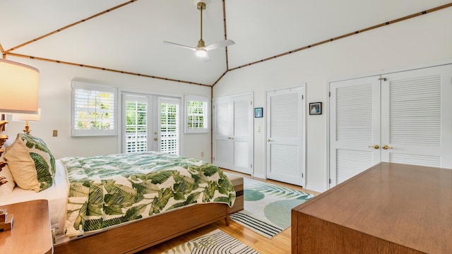 bedroom with two closets, high vaulted ceiling, wood-type flooring, access to exterior, and ceiling fan