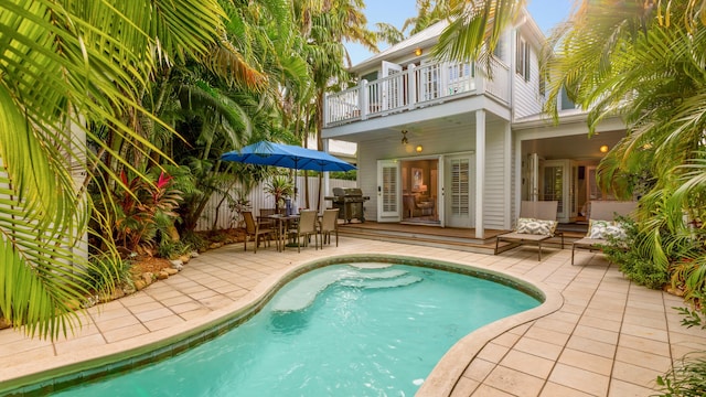 view of swimming pool with grilling area, a patio area, and ceiling fan