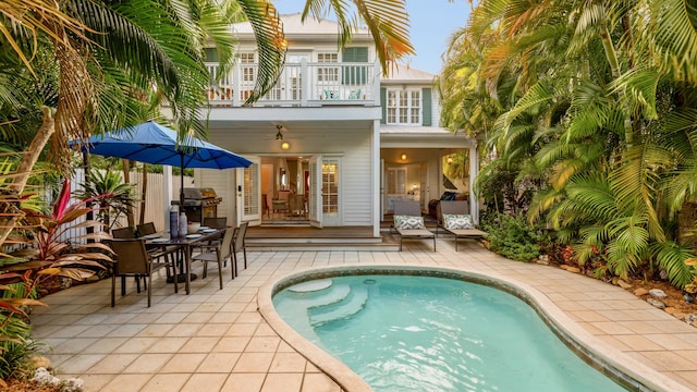 back of house featuring ceiling fan, a balcony, and a patio