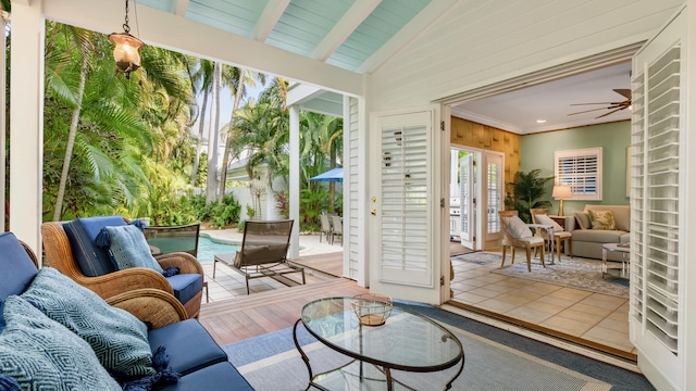 sunroom / solarium featuring lofted ceiling with beams