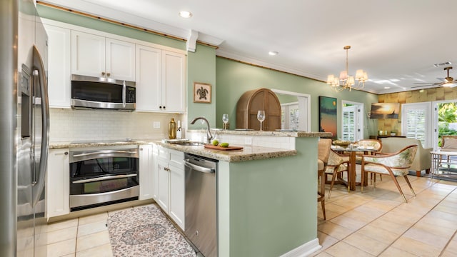 kitchen with white cabinetry, stainless steel appliances, kitchen peninsula, and hanging light fixtures