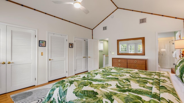 bedroom with ensuite bath, ceiling fan, high vaulted ceiling, multiple closets, and light wood-type flooring