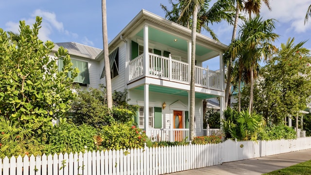 coastal inspired home with a porch and a balcony