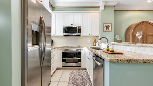 kitchen featuring sink, white cabinets, ornamental molding, light stone counters, and stainless steel appliances