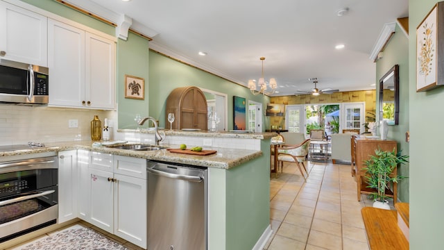 kitchen with white cabinetry, appliances with stainless steel finishes, sink, and kitchen peninsula