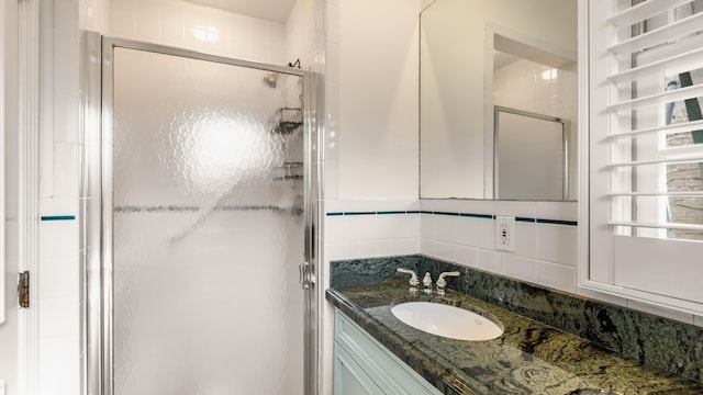 bathroom featuring tasteful backsplash, vanity, and walk in shower