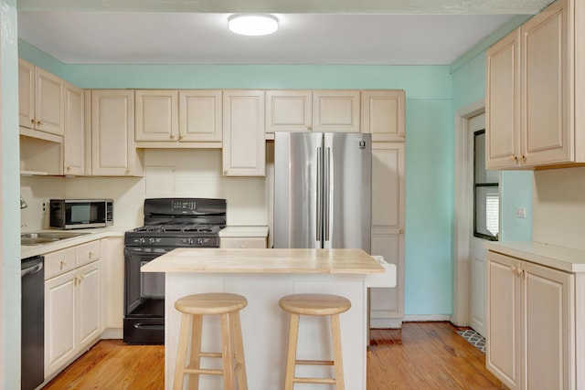 462 Sunset Dr, Key Largo, FL 33037 - kitchen featuring appliances with stainless steel finishes, light countertops, a kitchen island, and light wood finished floors