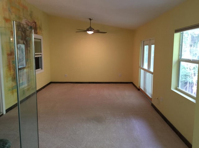 carpeted spare room with ceiling fan