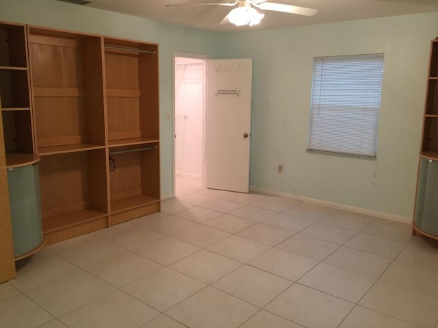 unfurnished bedroom featuring light tile patterned floors, ceiling fan, and a closet