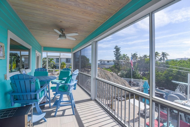 sunroom with ceiling fan, a healthy amount of sunlight, and wooden ceiling