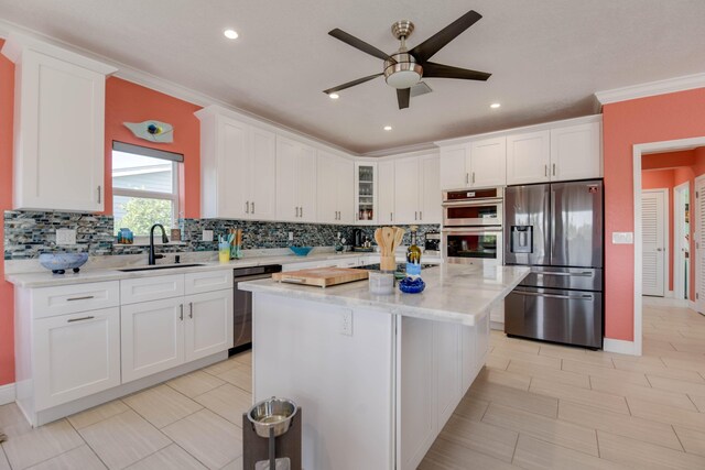 kitchen featuring light stone counters, a kitchen island, white cabinets, and appliances with stainless steel finishes