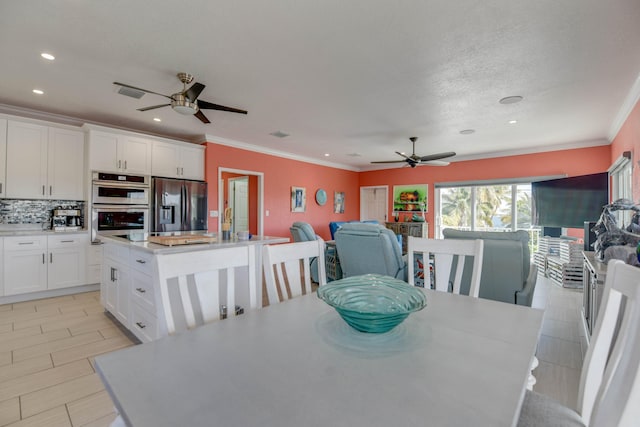 dining room featuring crown molding, a textured ceiling, and ceiling fan